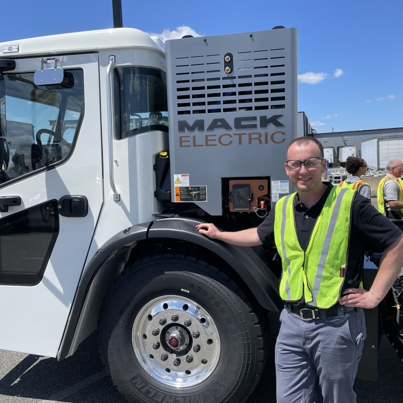 Dan Robb next to an electric mack truck. 